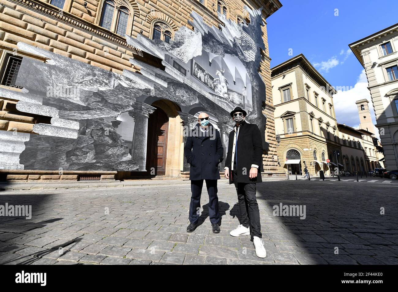 El artista contemporáneo francés JR (R) posa con Arturo Galanzino, director  del Palazzo Strozzi, frente a su instalación artística en la fachada del  palacio titulada 'la Ferita (la herida)', Y mostrando una