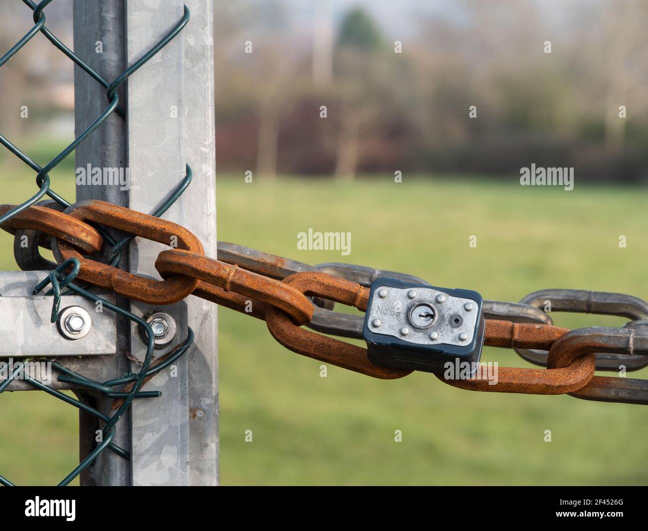 Candado y cadena corroída en las puertas al espacio verde local en Westbury, Wiltshire, Inglaterra, Reino Unido. Foto de stock
