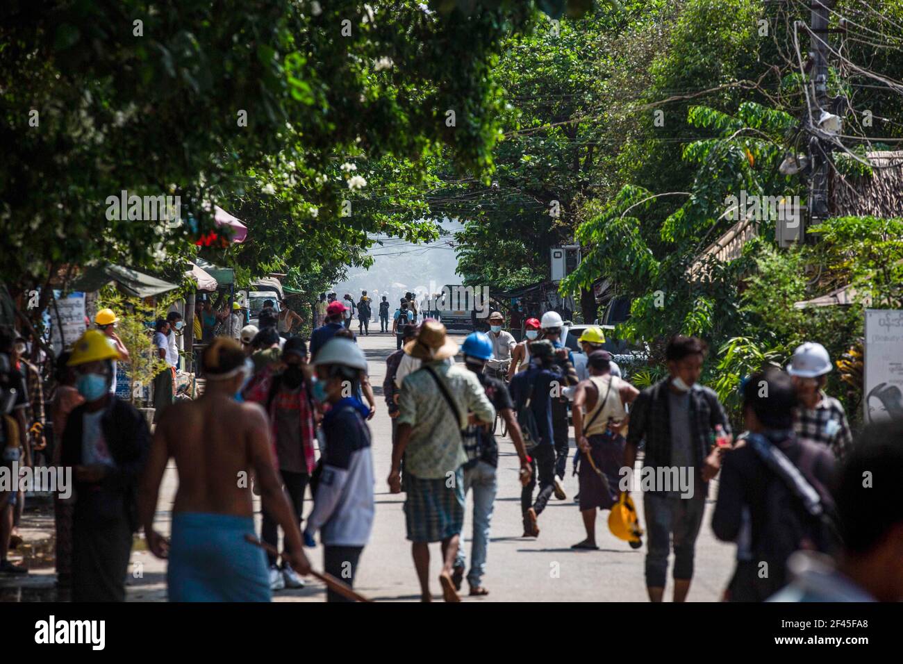 Los manifestantes contra el golpe militar caminan hacia las barricadas improvisadas al final de la calle durante una manifestación contra el golpe militar.la policía y los soldados militares de Myanmar (tatmadow) atacaron a los manifestantes con balas de goma, municiones vivas, gas lacrimógeno y bombas de aturdimiento en respuesta a los manifestantes contra el golpe militar el viernes, matando a varios manifestantes e hirió a muchos otros. Al menos 149 personas han sido asesinadas en Myanmar desde el golpe de Estado del 1 de febrero, dijo un funcionario de derechos humanos de la ONU. El ejército de Myanmar detuvo a la Consejera de Estado de Myanmar, Aung San Suu Kyi, el 01 de febrero de 2021, y declaró a la Sra. Foto de stock