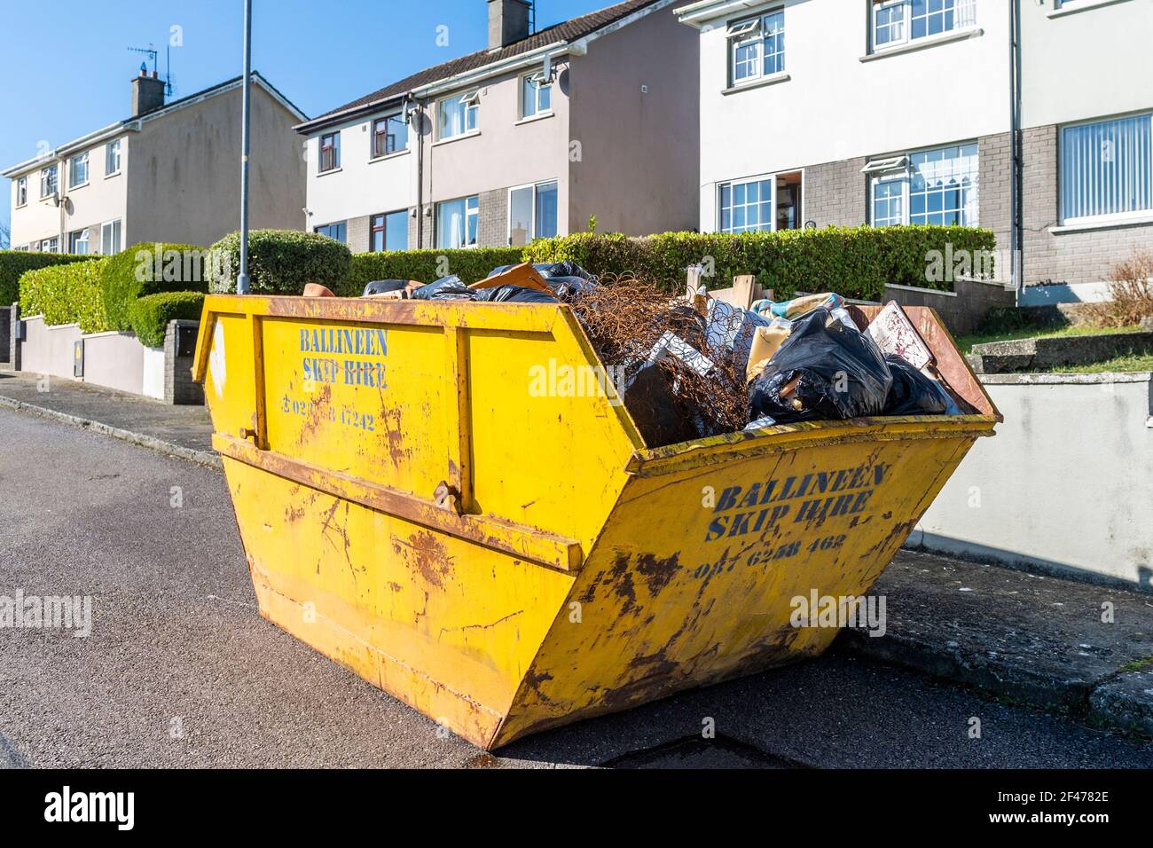 Hire sáltate lleno de basura doméstica en una vivienda en Irlanda. Foto de stock