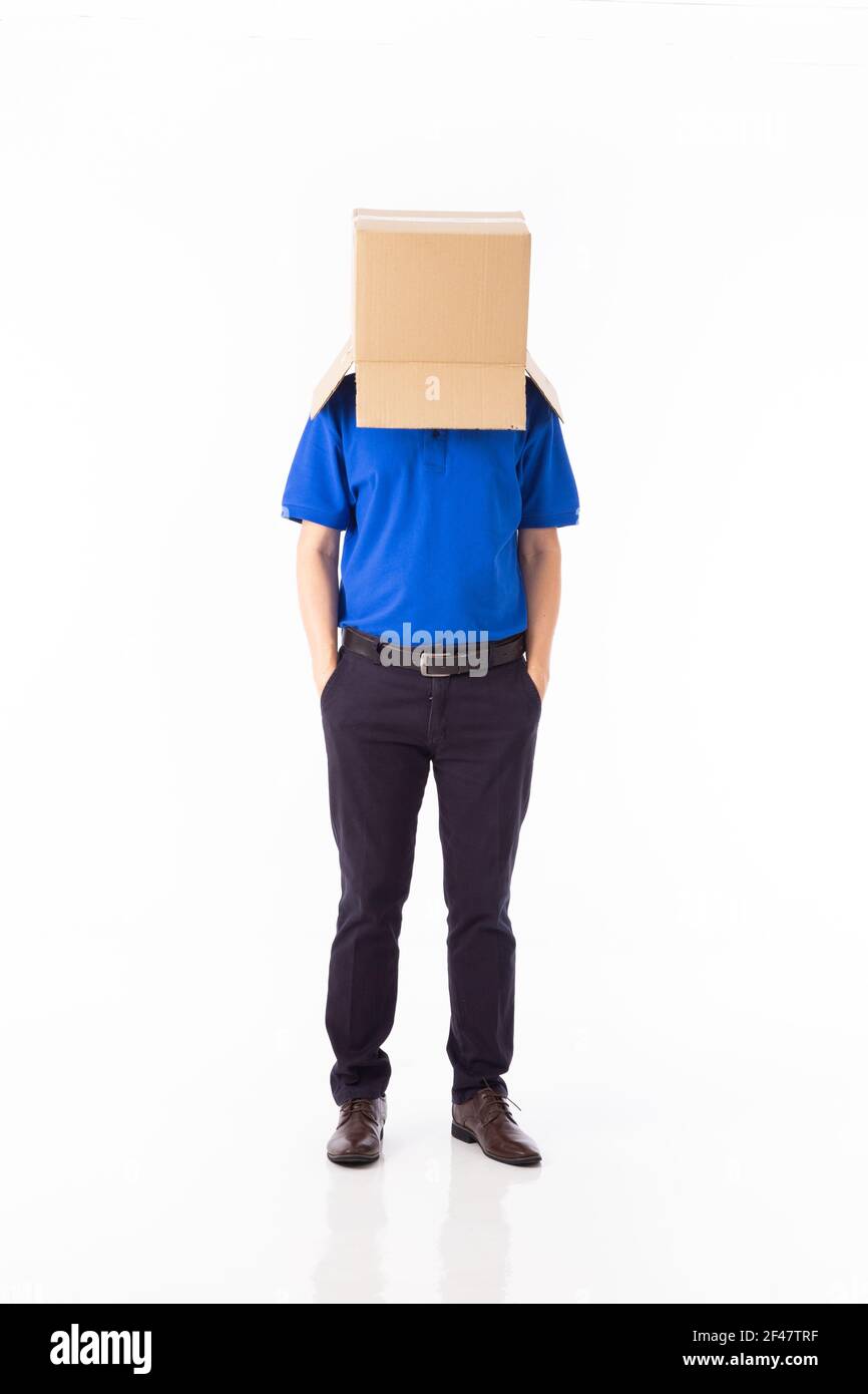 Hombre en una camiseta más azul con una caja de cartón su cabeza hace un gesto con sus manos aisladas fondo blanco Foto de stock