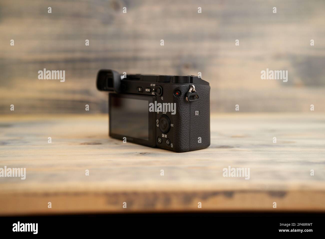 Budva, Montenegro - 15 de marzo de 2021: Cámara Sony A6300 con lente 16-50mm sobre textura de fondo de madera. Cámara sin espejo de Sony. Foto de stock