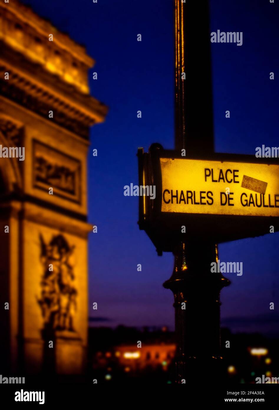 Letrero iluminado para Place Charles de Gaulle al atardecer, con el Arco del Triunfo fuera de foco en el fondo, en abril de 2002 Foto de stock