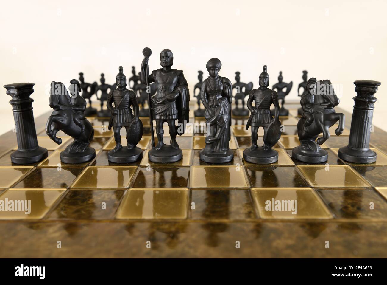 Piezas de ajedrez de metal negro en tablero de ajedrez con peones detrás del castillo caballero centurión rey y reina Foto de stock