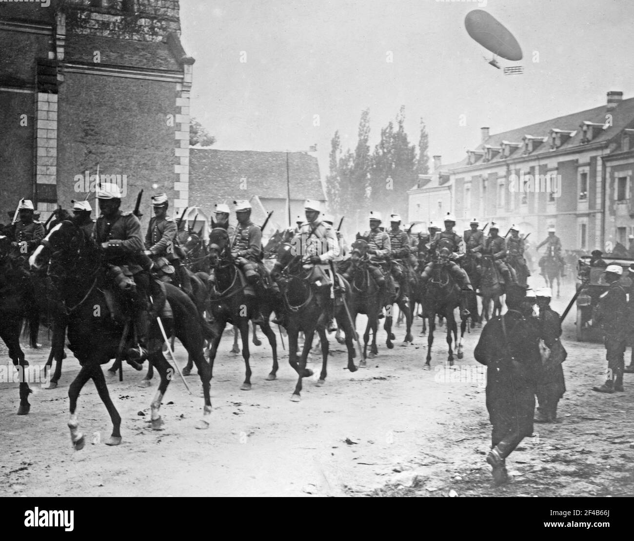 Soldados franceses a caballo en la calle, con el avión Dupuy de Lomé volando en el aire detrás de ellos durante la primera Guerra Mundial ca. 1914-1915 Foto de stock