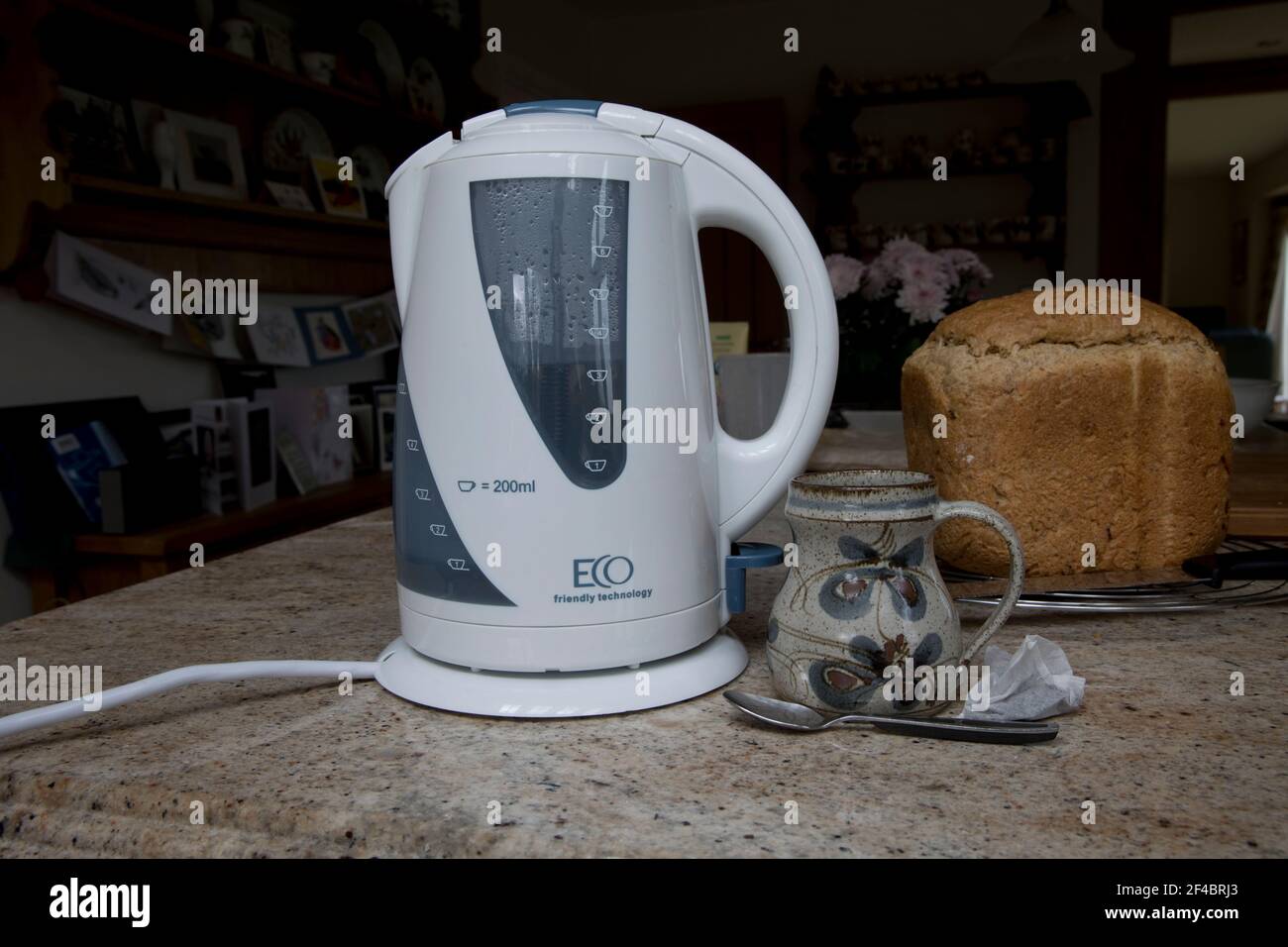 Hervidor de agua blanco ecológico de bajo consumo en la encimera de la  cocina con taza de té y pan fresco Fotografía de stock - Alamy