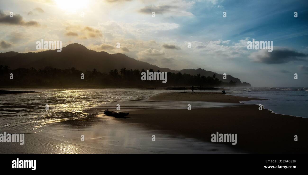 El río Palomino y el océano Caribe se reúnen al atardecer en Palomino, Colombia. Foto de stock