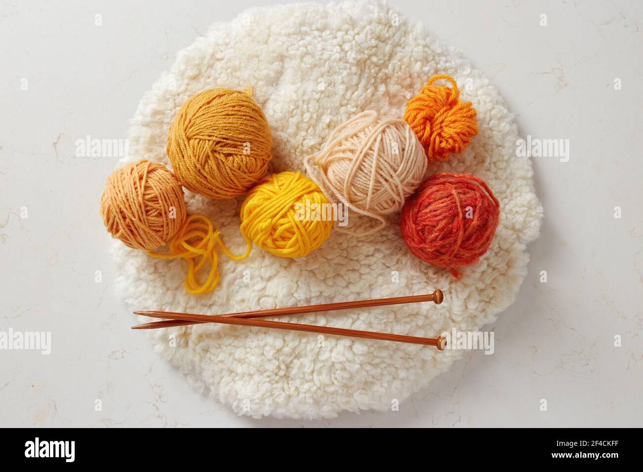 Agujas de punto y bolas de lana de colores. Bolas de lana parcialmente desenrollado. Foto de stock