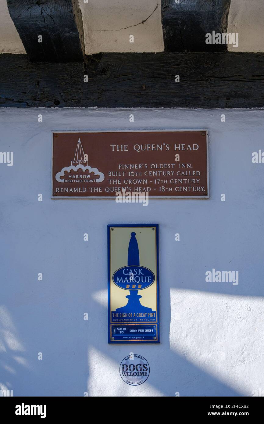 Señales en el Queen's Head Historic Pub y la posada más antigua en Pinner, construido en el siglo 16th. Premio al pub cask Marque, Dogs Welcome & Harrow Heritage Trust. Foto de stock