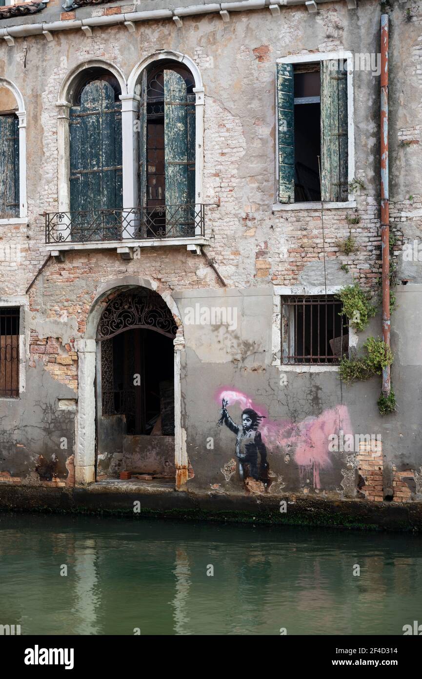 Venecia. Italia. Las obras de arte de Banksy (mayo de 2019) retratan a un niño migrante usando un chaleco salvavidas mientras sostiene una llamarada rosa, cerca de campo Santa Margherita in Foto de stock