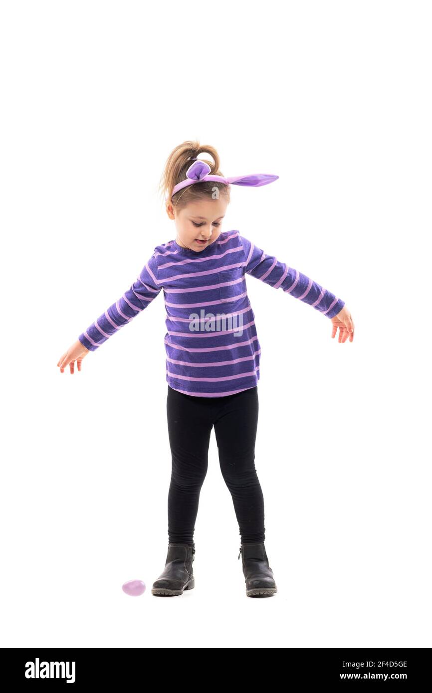 Feliz baile niña girando con las manos abiertas mirando hacia abajo con el  sombrero de orejas de conejo. Cuerpo entero aislado sobre fondo blanco  Fotografía de stock - Alamy