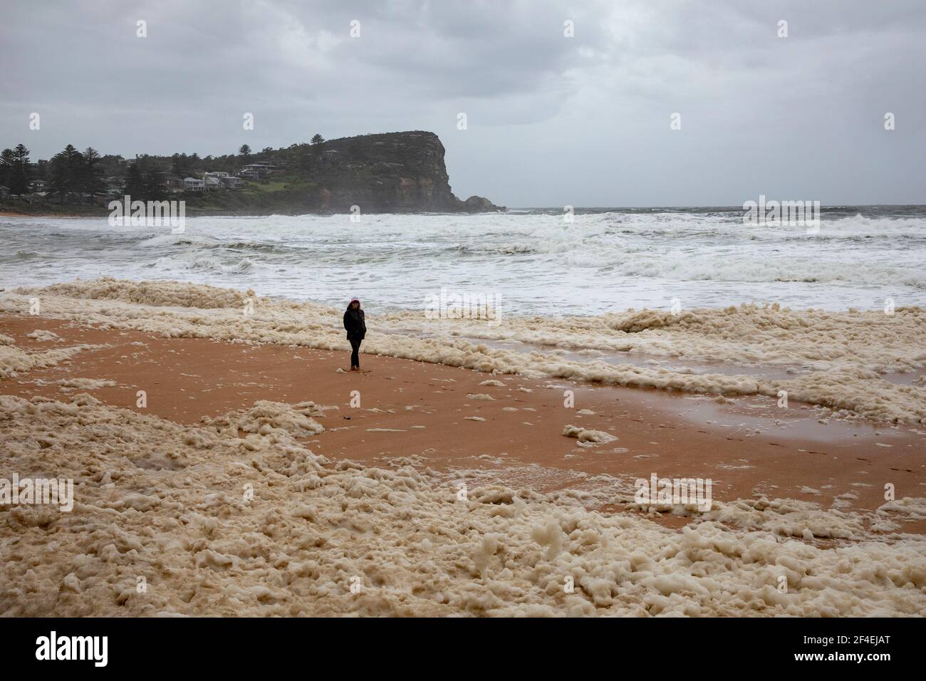 Avalon Beach,Sydney, Australia 21st de marzo de 2021.a medida que las inundaciones baten Nueva Gales del Sur, el surf de la costa este batea la costa. La señora camina por el mar Foto de stock