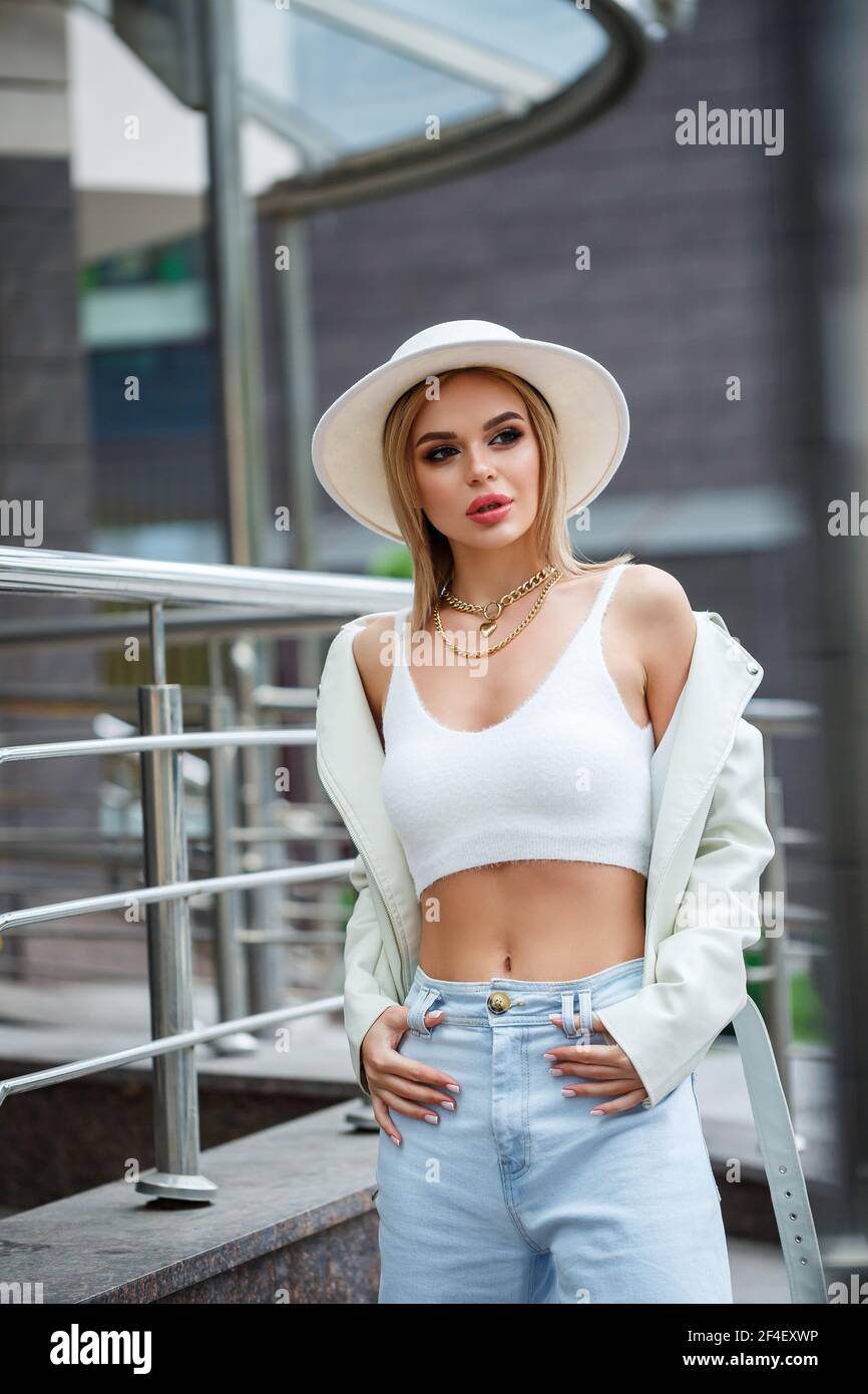 Retrato de una hermosa mujer joven de negocios. Vestido con ropa elegante.  Relajarse en un día cálido al aire libre cerca de un edificio de oficinas  Fotografía de stock - Alamy