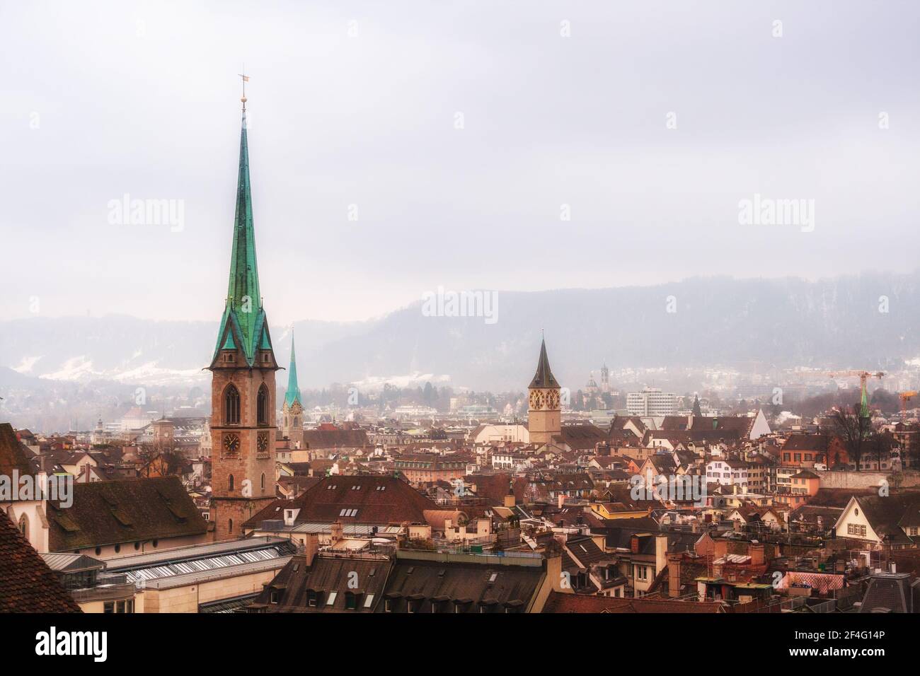 Vista de Zurich en un día de invierno foggy. Agujas góticas de las iglesias en el fondo de la cresta de los Alpes Foto de stock