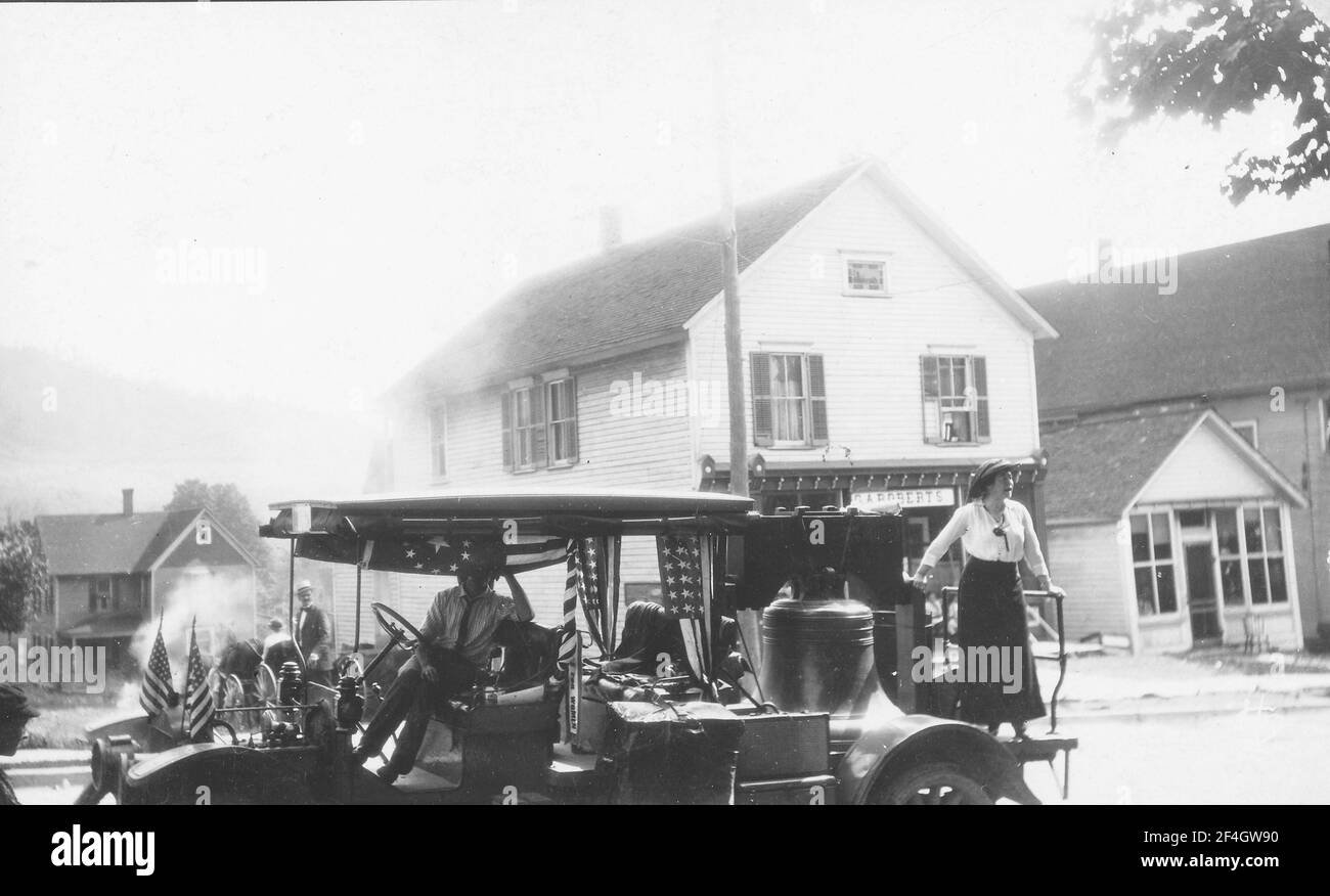 Vista de perfil de un camión que lleva la Campana de la Justicia, una réplica de la Campana de la Libertad fundida por los sufragios de Pennsylvanian y utilizado para hacer campaña entre 1915 y 1920, con una mujer de pie en la cama y un hombre en el asiento del conductor, Pensilvania, 1915. () Foto de stock