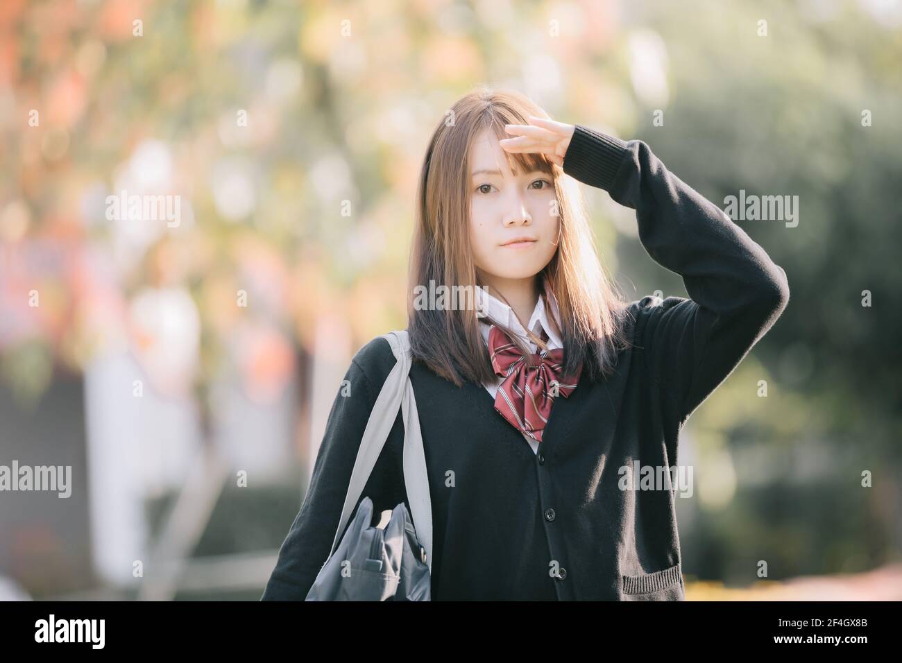 Retrato del traje de la niña de la escuela japonesa asiática mirando al parque película al aire libre estilo vintage Foto de stock