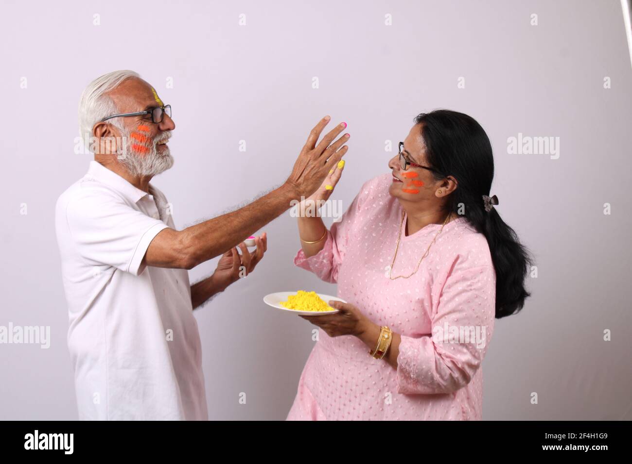 pareja de ancianos o ancianos de la india celebrando holi con color Foto de stock