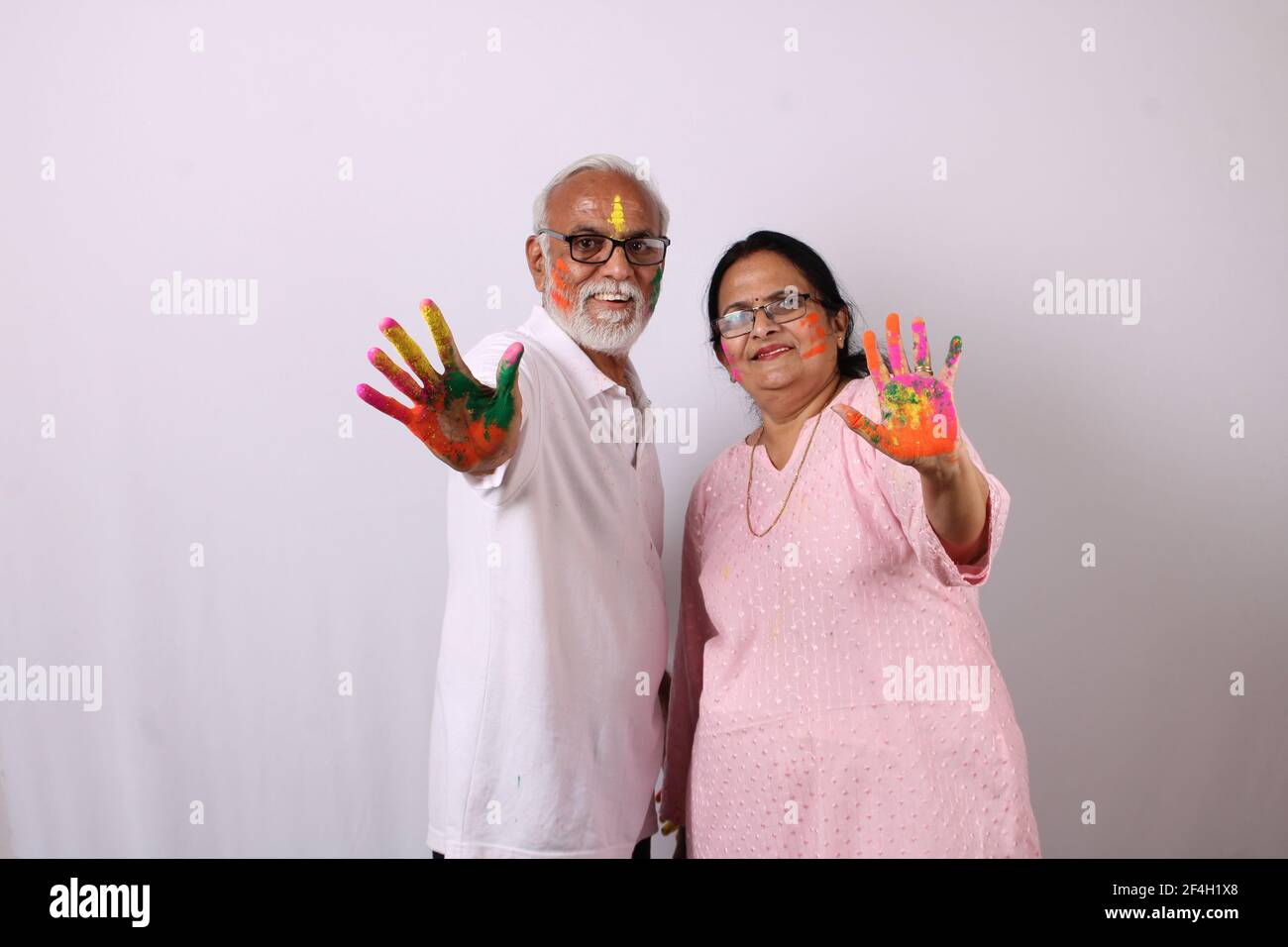 pareja de ancianos o ancianos de la india celebrando holi con color Foto de stock
