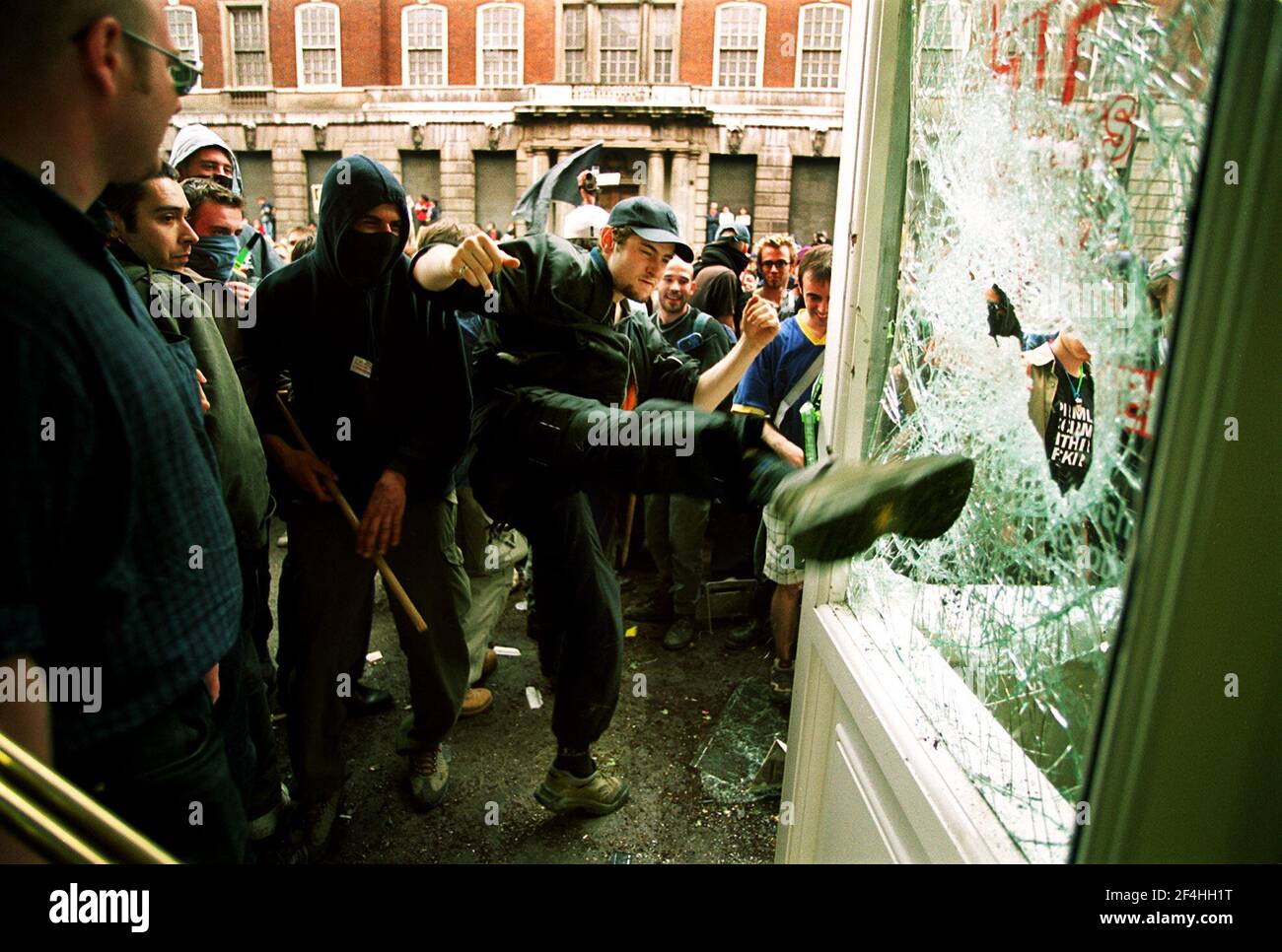 El rioter anticapitalista se pone en una ventana los manifestantes del 2000as de mayo Ve a la marcha en Londres durante el anticapitalista Demostraciones de mayo Foto de stock