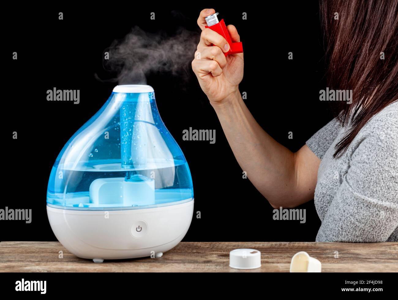 Asma, concepto de ataque de alergia con humidificador de aire ultrasónico  que crea neblina fría y una mujer que sostiene un inhalador para  administrar broncodilatadores o steroi Fotografía de stock - Alamy