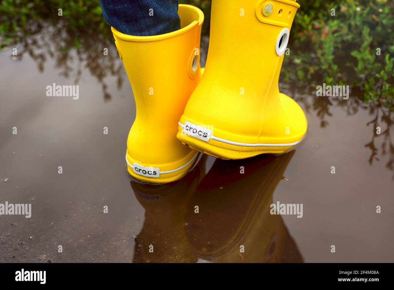 Tambov, Federación Rusa - 08 de agosto de 2019 Mujer en amarillo Crocs botas  en el charco. Primer plano Fotografía de stock - Alamy