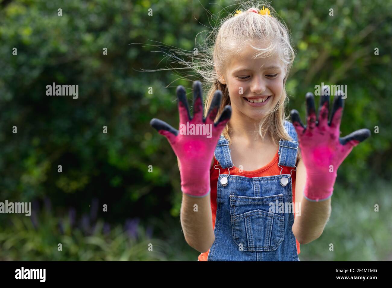 Las manos de una mujer con guantes de jardinería sostienen un
