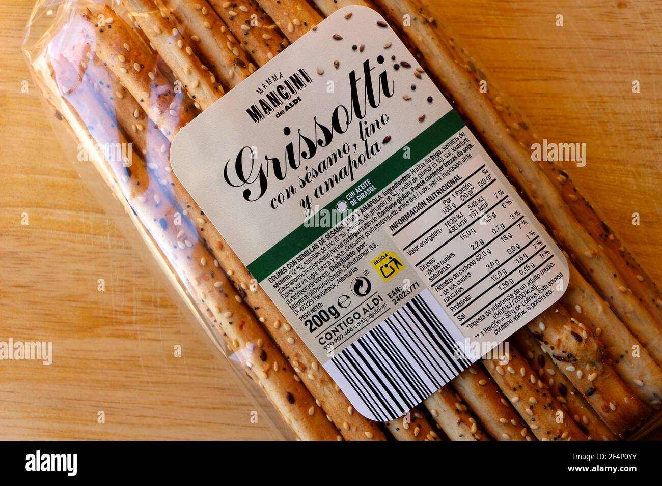 Paquete de Grissotti palitos de pan finos italianos con lino de sésamo y  Semillas de amapola en envases de plástico de un supermercado Aldi en  España en una tabla de madera Fotografía