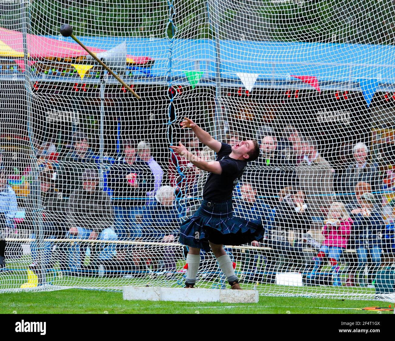 Atleta compitiendo en el evento de lanzamiento de martillo en los Juegos de Ballarer Highland, Aberdeenshire, Escocia. Foto de stock