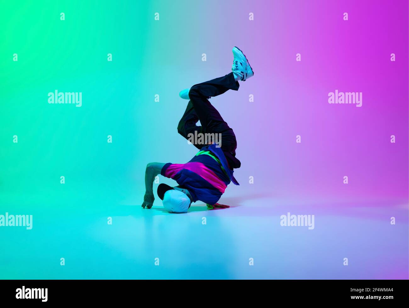 Hermoso niño deportivo bailando hip-hop en ropa con estilo sobre fondo de  gradiente colorido en la sala de baile con luz de neón Fotografía de stock  - Alamy