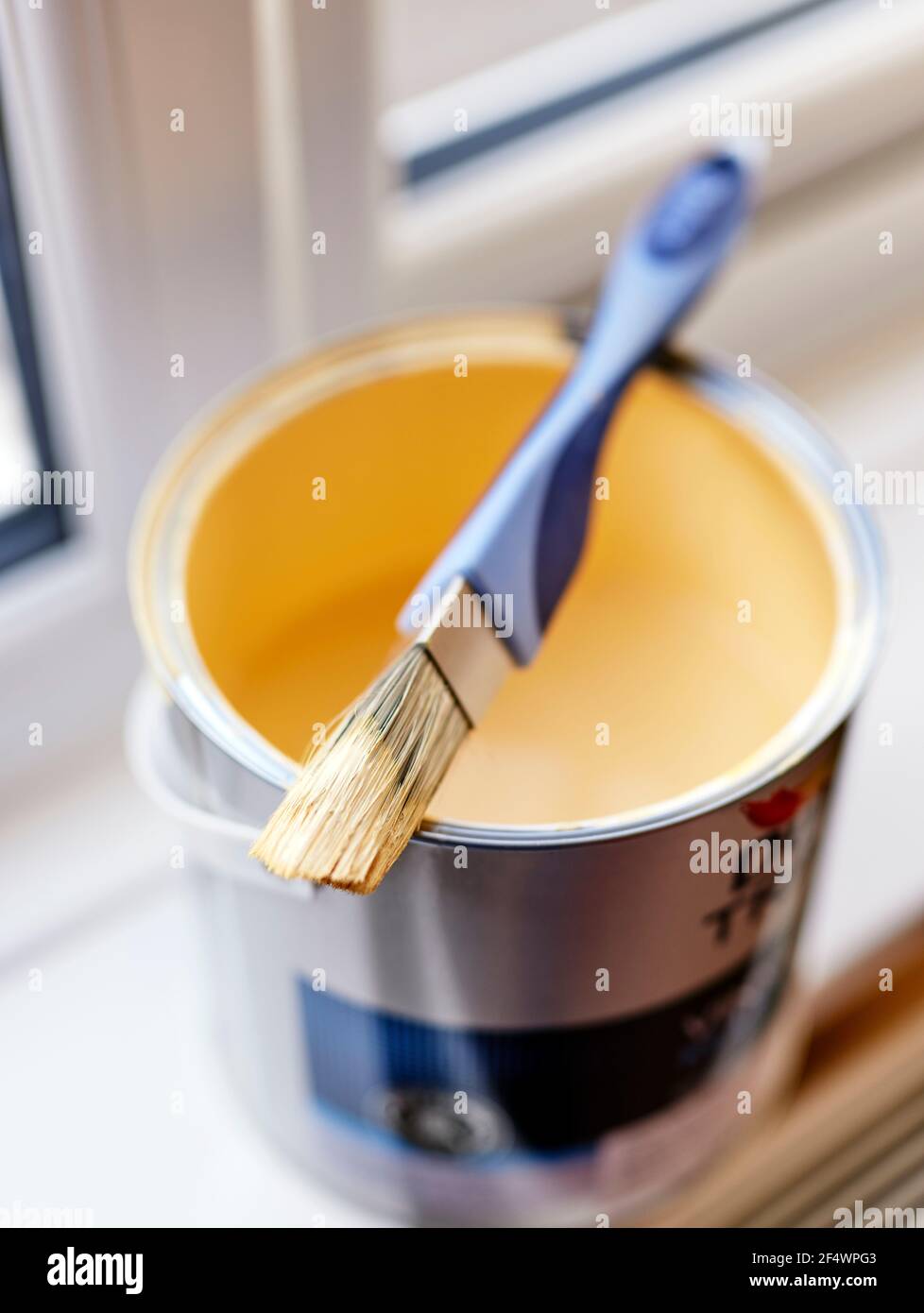 Cepillo de pintura apoyado sobre estaño de pintura abierto Foto de stock