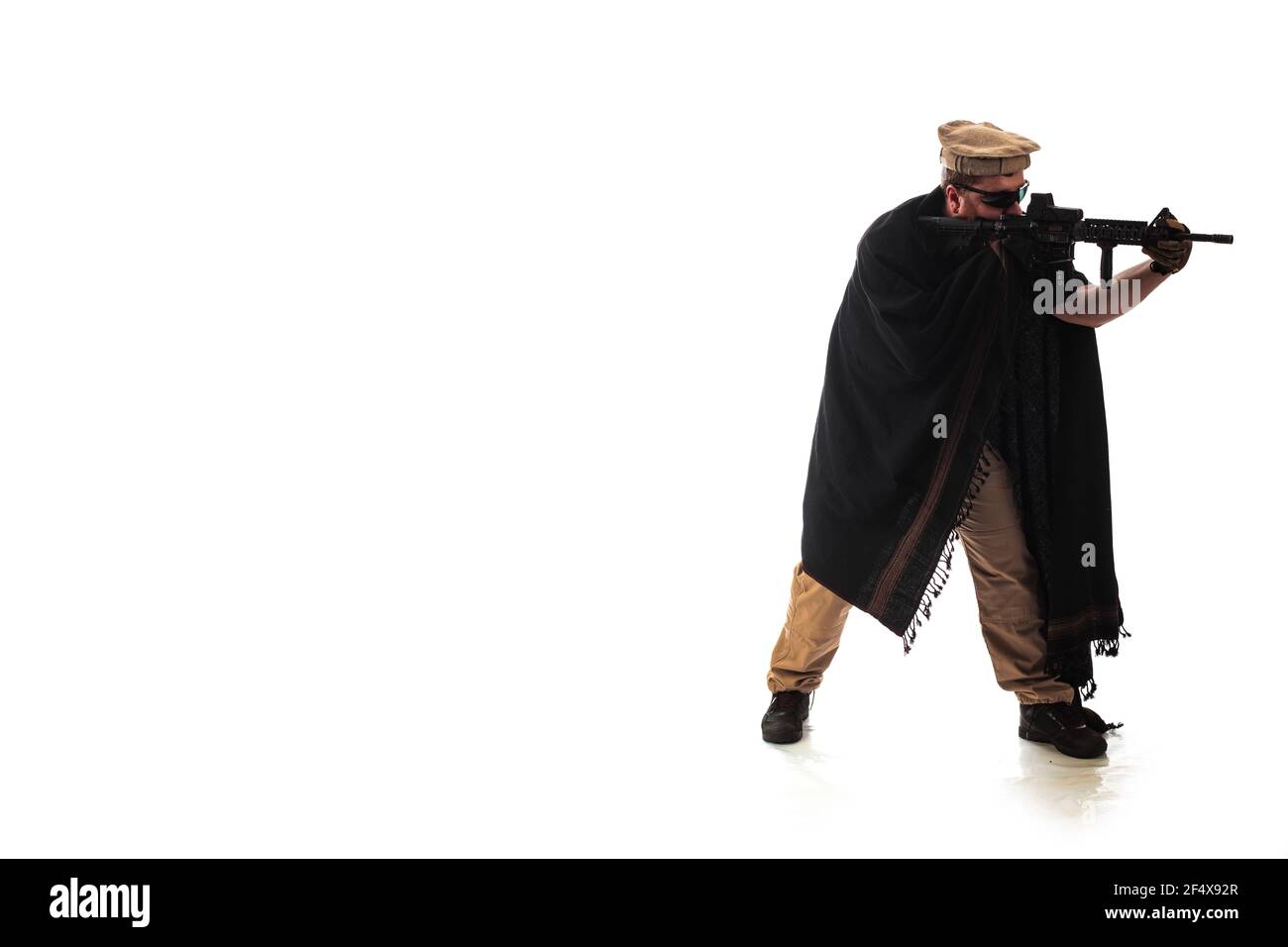 Hombre en traje militar agente de la CIA, que es similar a la ropa de un  guerrero Mujahidín, en tiempos modernos sobre un fondo blanco en estudio  Fotografía de stock - Alamy