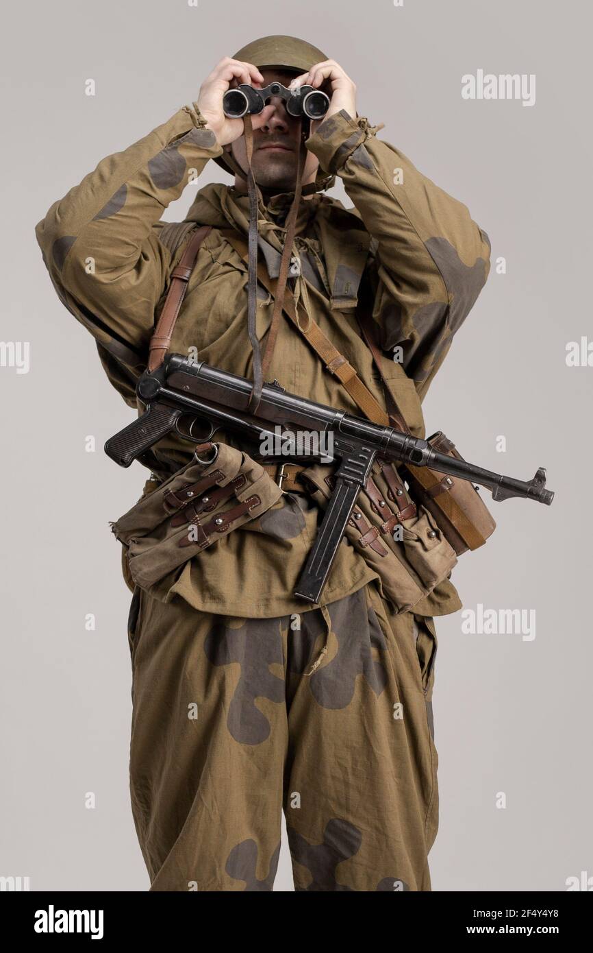 Hombre adulto con prismáticos en la mano en un viejo uniforme militar y ropa  de camuflaje de un soldado del ejército soviético durante la Segunda Guerra  Mundial, 1943 Fotografía de stock - Alamy