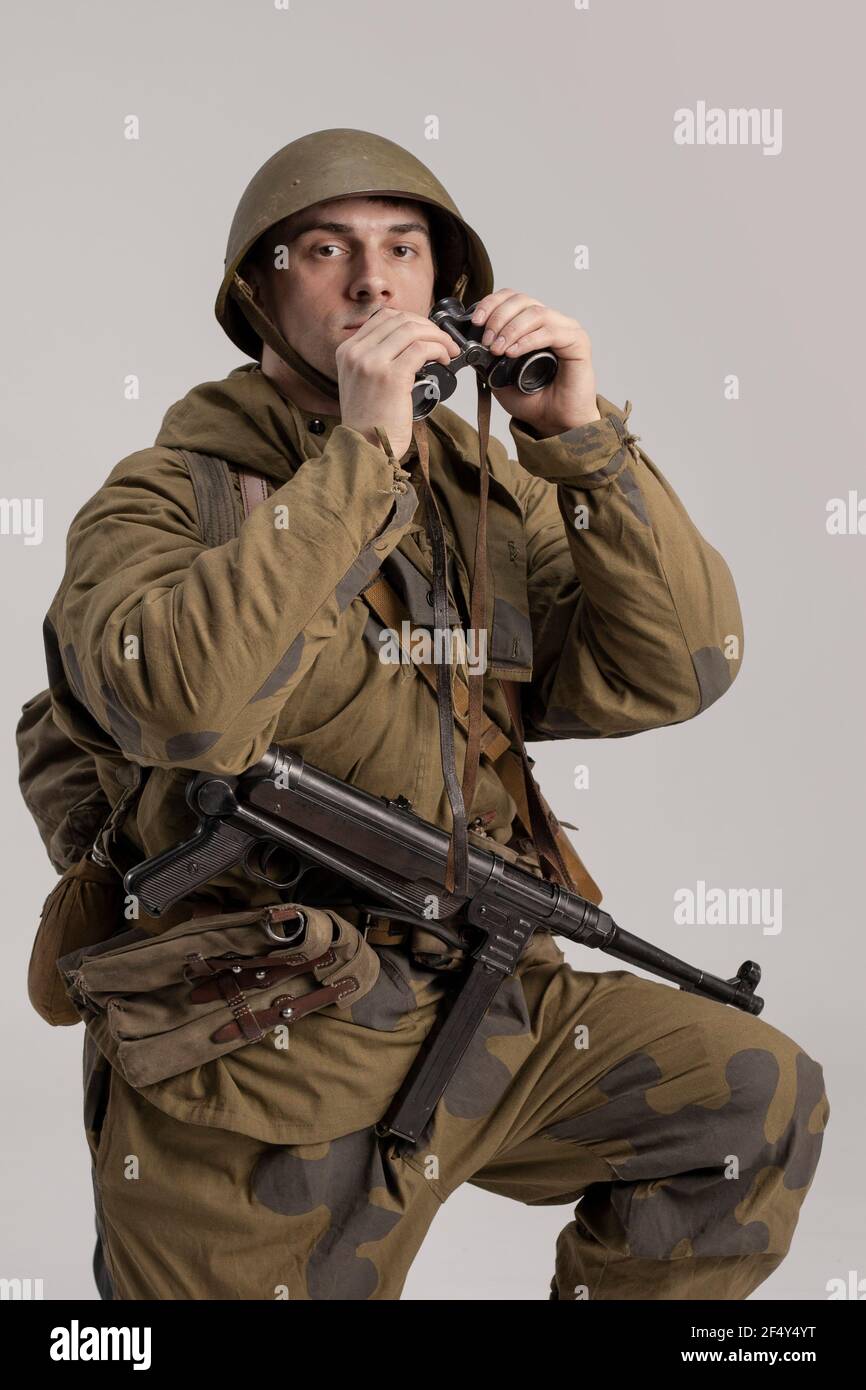 Hombre adulto con prismáticos en la mano en un viejo uniforme militar y ropa de un soldado del ejército soviético durante la Segunda Guerra Mundial, 1943 Fotografía de stock - Alamy