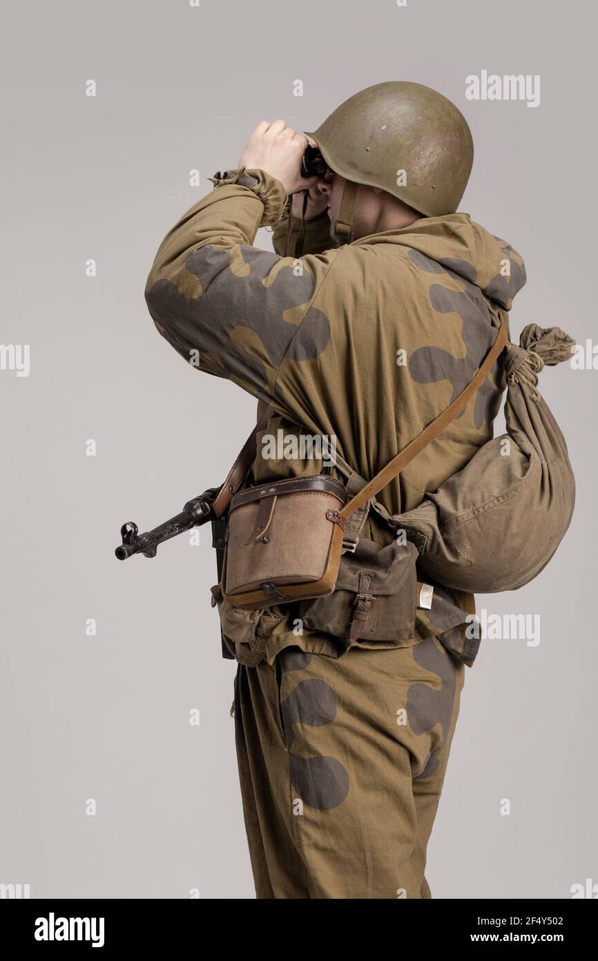 Hombre adulto con prismáticos en la mano en un viejo uniforme militar y ropa  de camuflaje de un soldado del ejército soviético durante la Segunda Guerra  Mundial, 1943 Fotografía de stock - Alamy