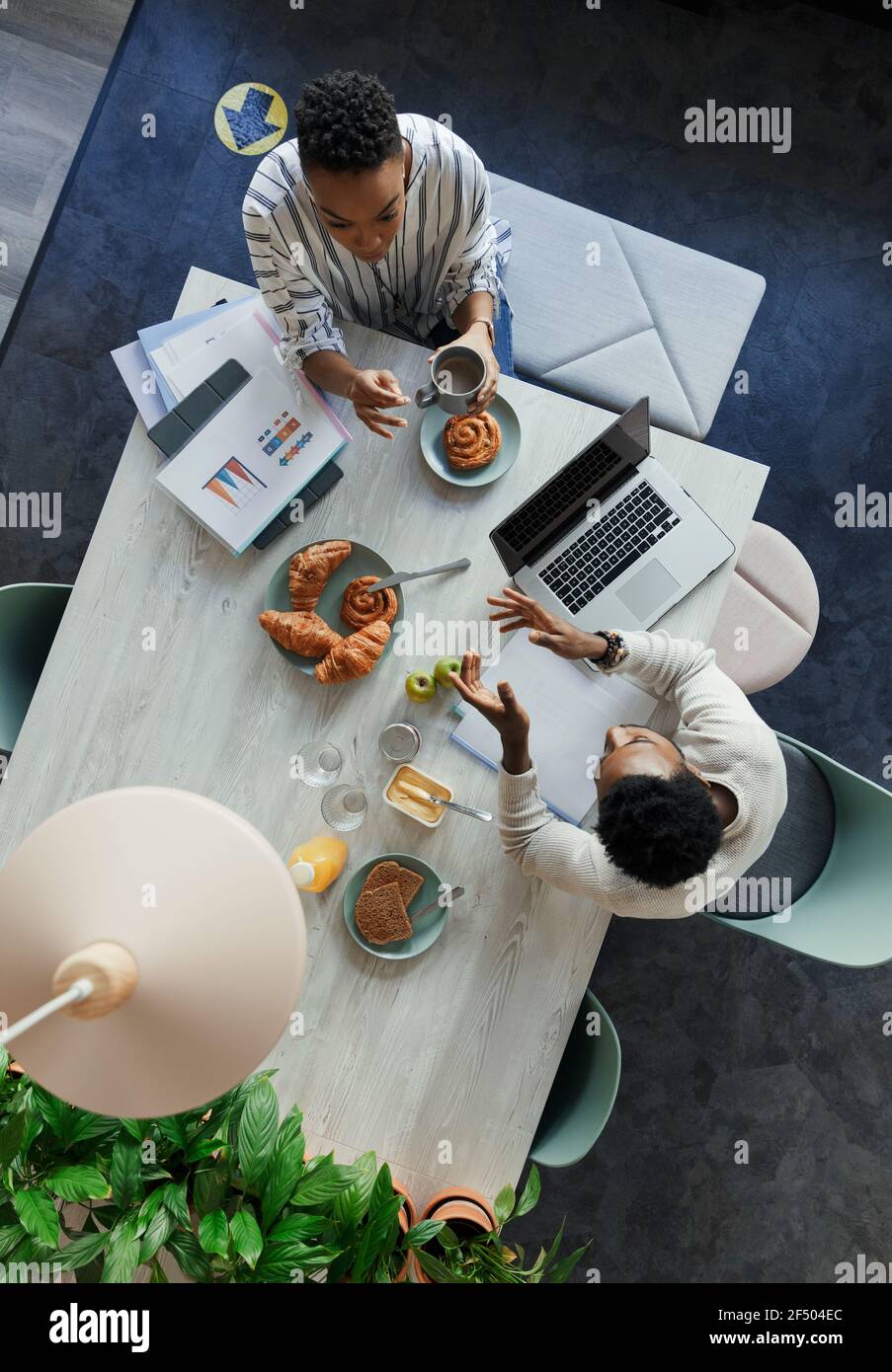 Gente de negocios se reúne durante el desayuno en la mesa de la oficina Foto de stock