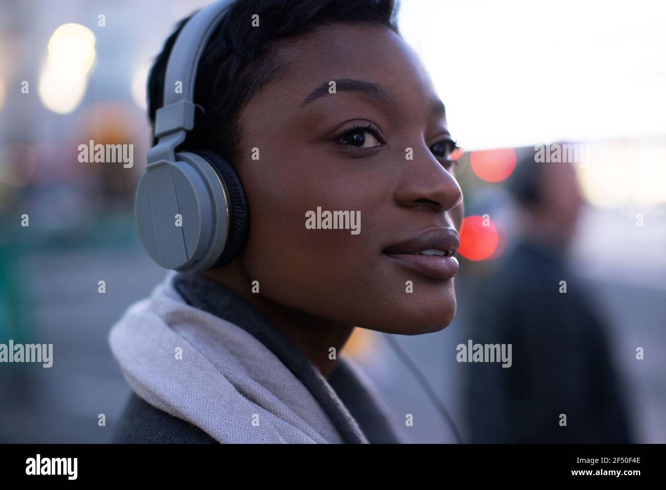 Primer plano hermosa mujer joven escuchando música con auriculares Foto de stock