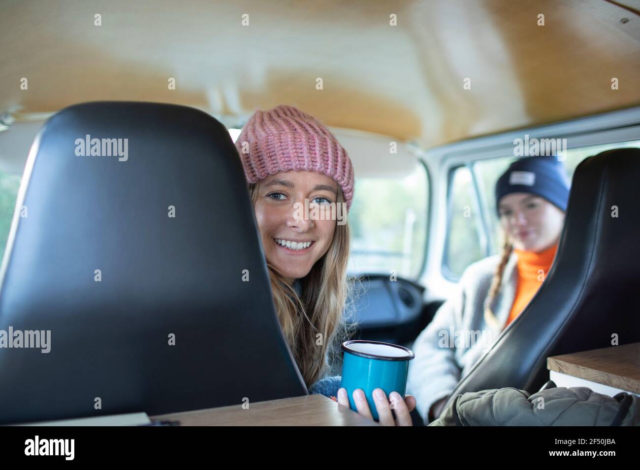 Retrato joven feliz bebiendo café dentro de la furgoneta Foto de stock