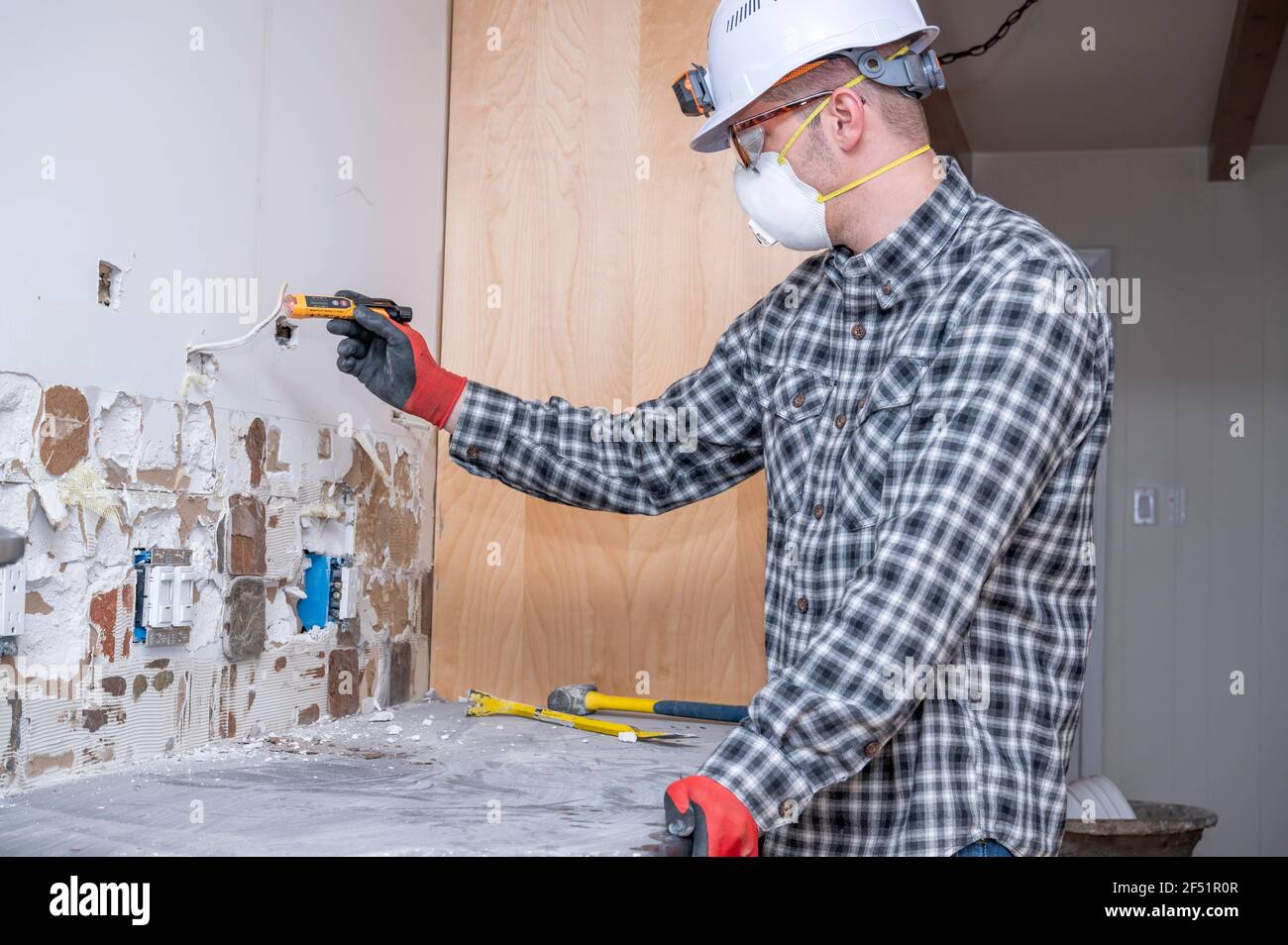 Electricista que usa equipo de seguridad que prueba el voltaje del cableado  eléctrico en la cocina del hogar durante el proyecto de remodelación  Fotografía de stock - Alamy