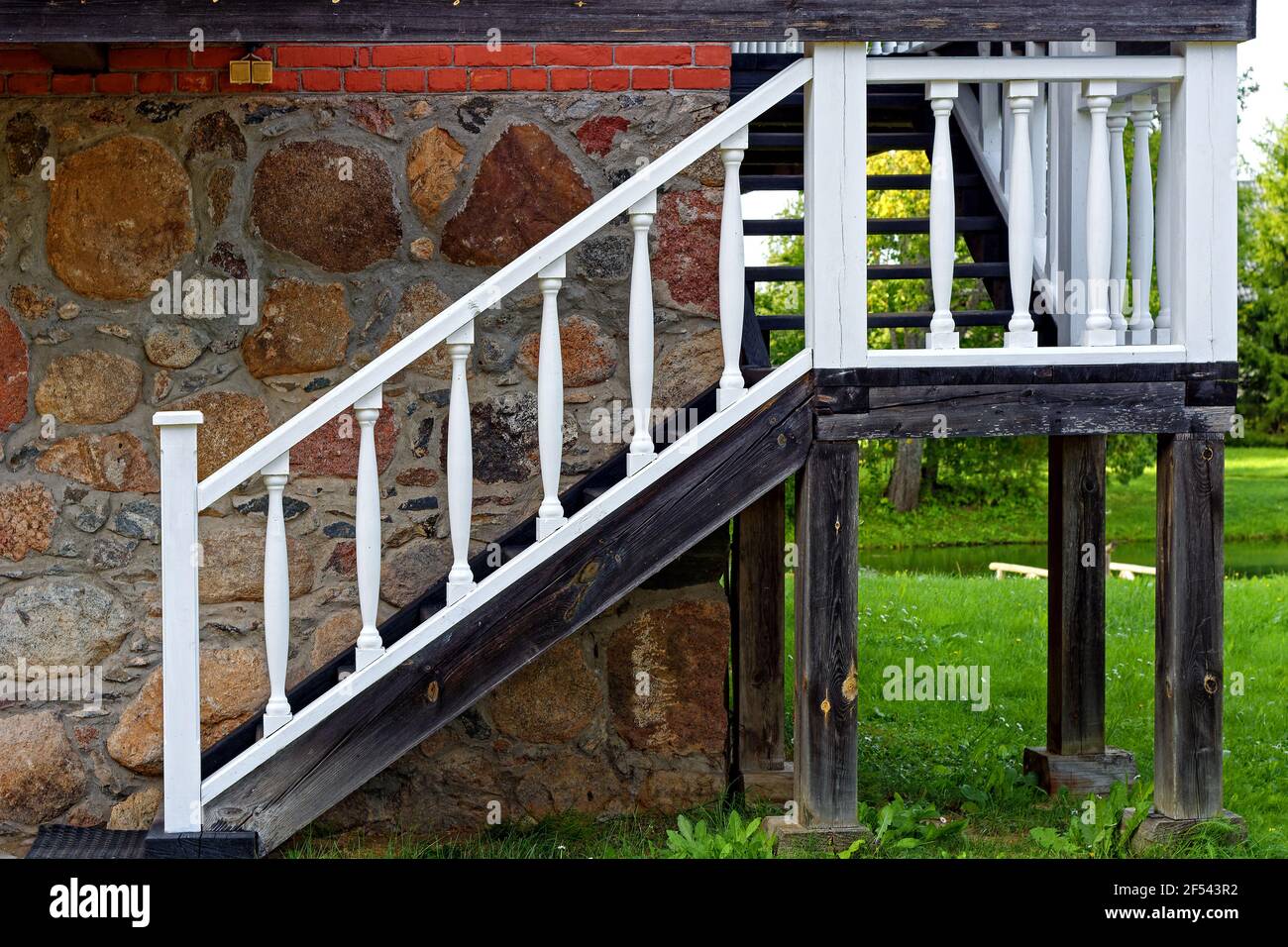Escalera de madera con barandillas blancas que conducen al segundo piso de  una casa de piedra en el parque de la finca Petrovskoye en Pushkin Gory  Fotografía de stock - Alamy