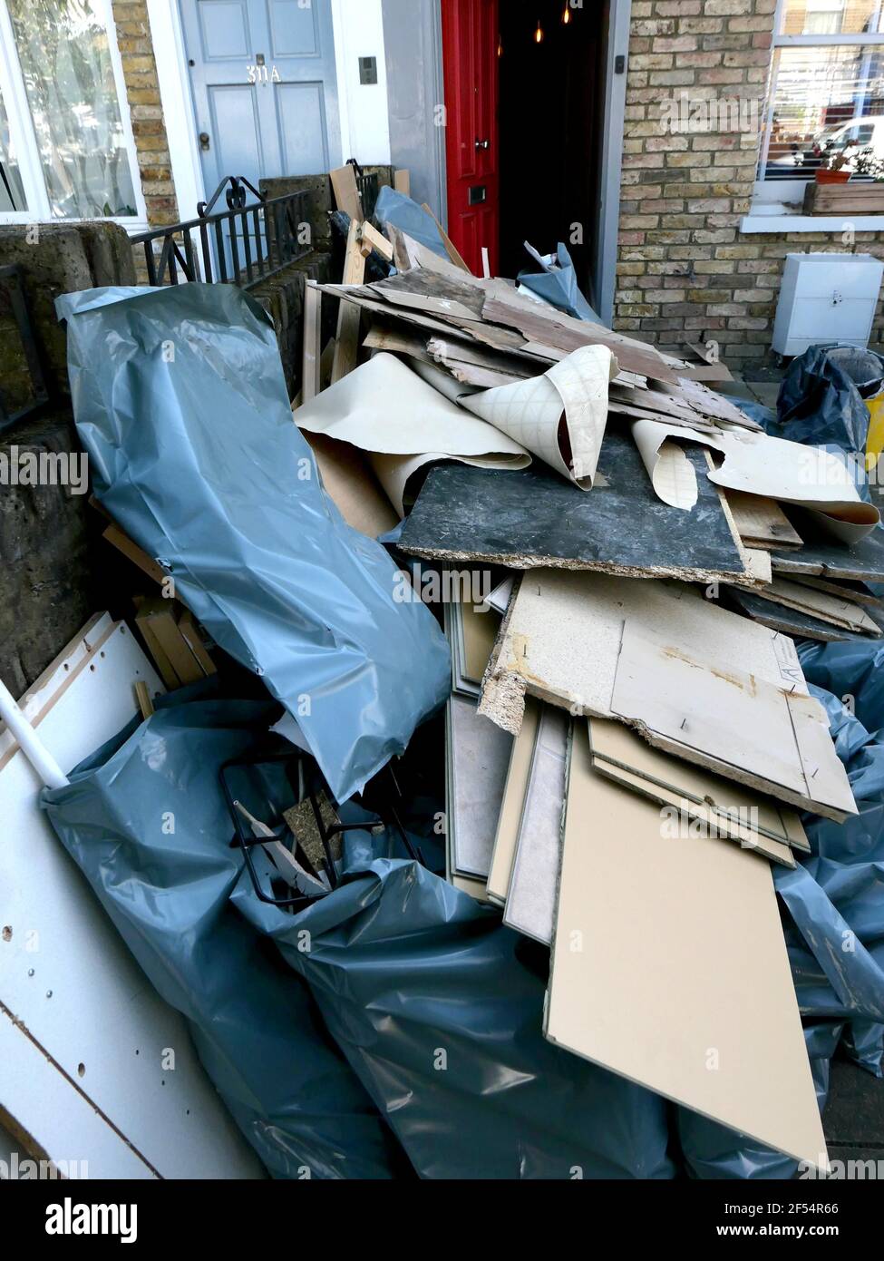 La basura de los constructores fuera de la casa se está renovando en el sur de Londres Foto de stock