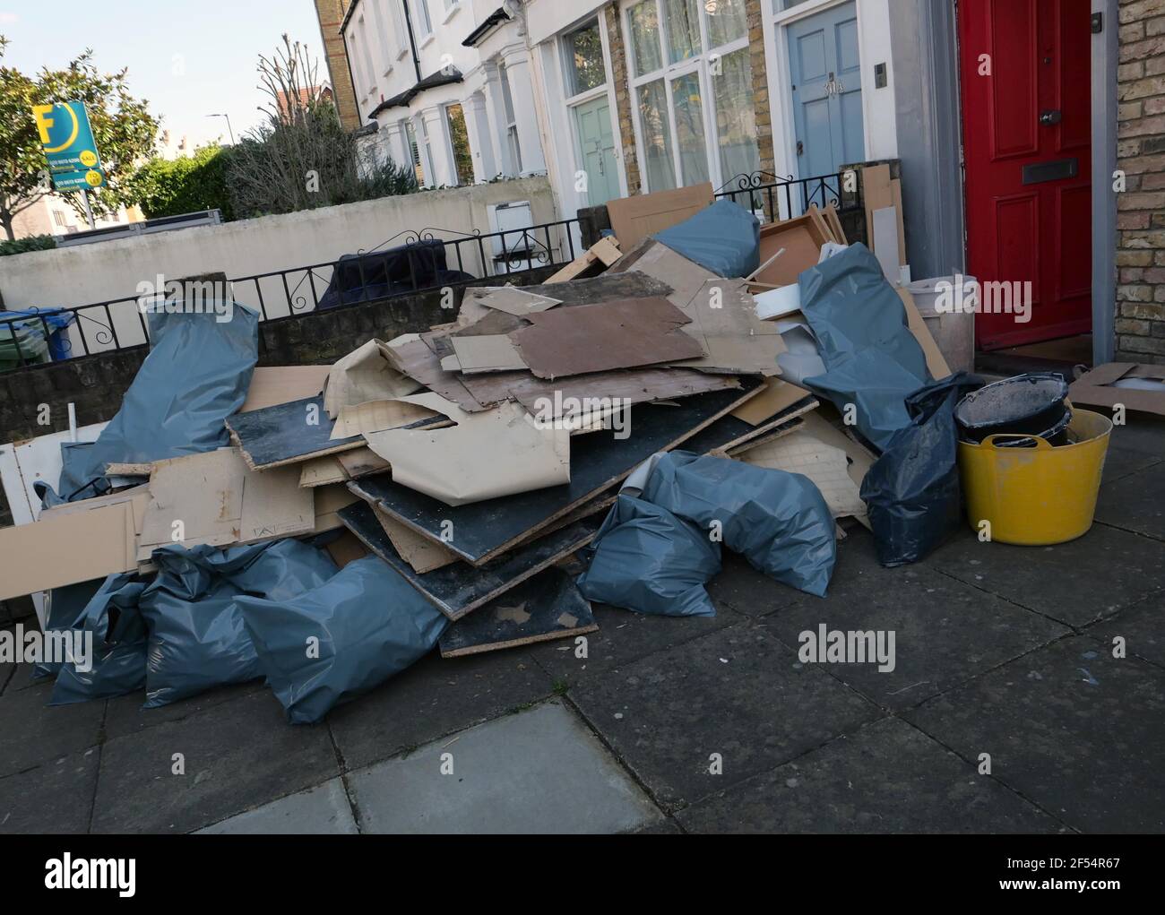 La basura de los constructores fuera de la casa se está renovando en el sur de Londres Foto de stock