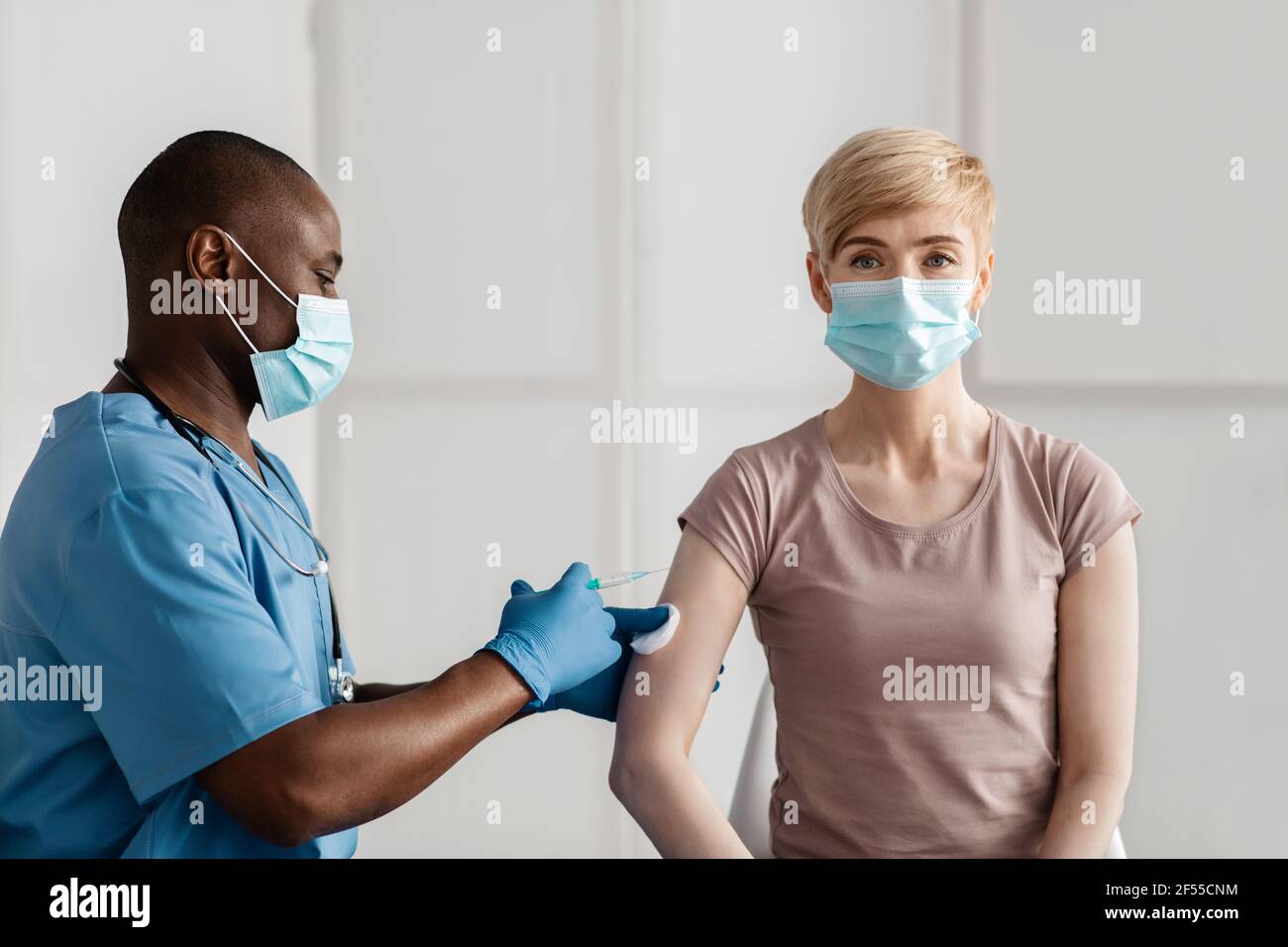 Vacunación, inmunización, prevención de enfermedades. La mujer adulta en máscara recibe covid-19 o la vacuna contra la gripe Foto de stock