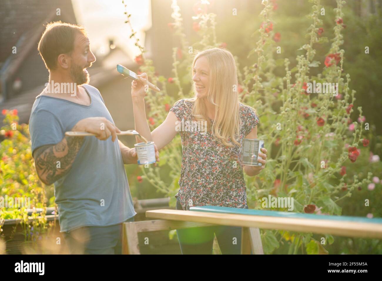 Mujer rubia haciendo travesuras con novio en el jardín Foto de stock