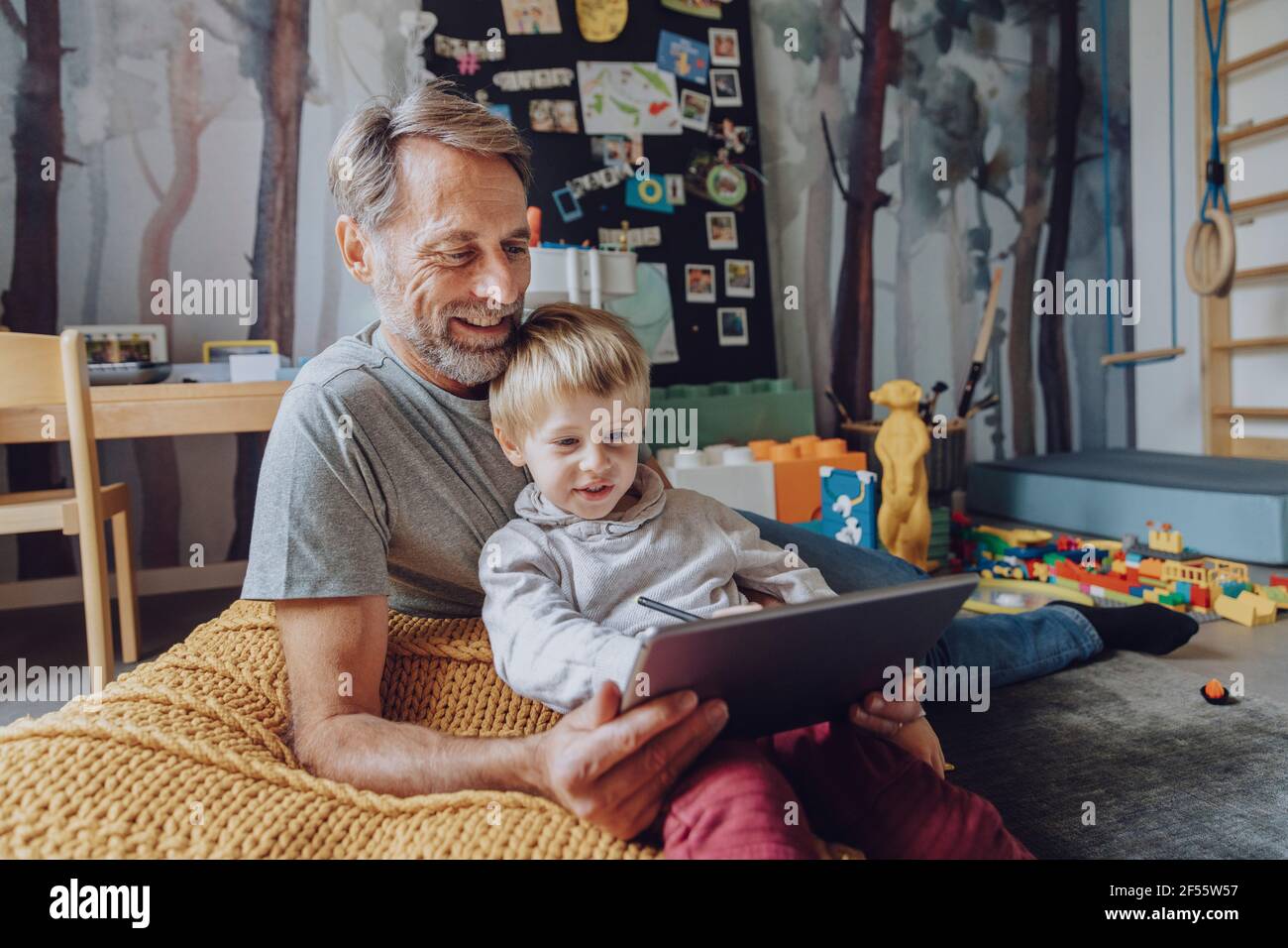 Sonriente padre con lindo hijo E-learning en la tableta digital Foto de stock