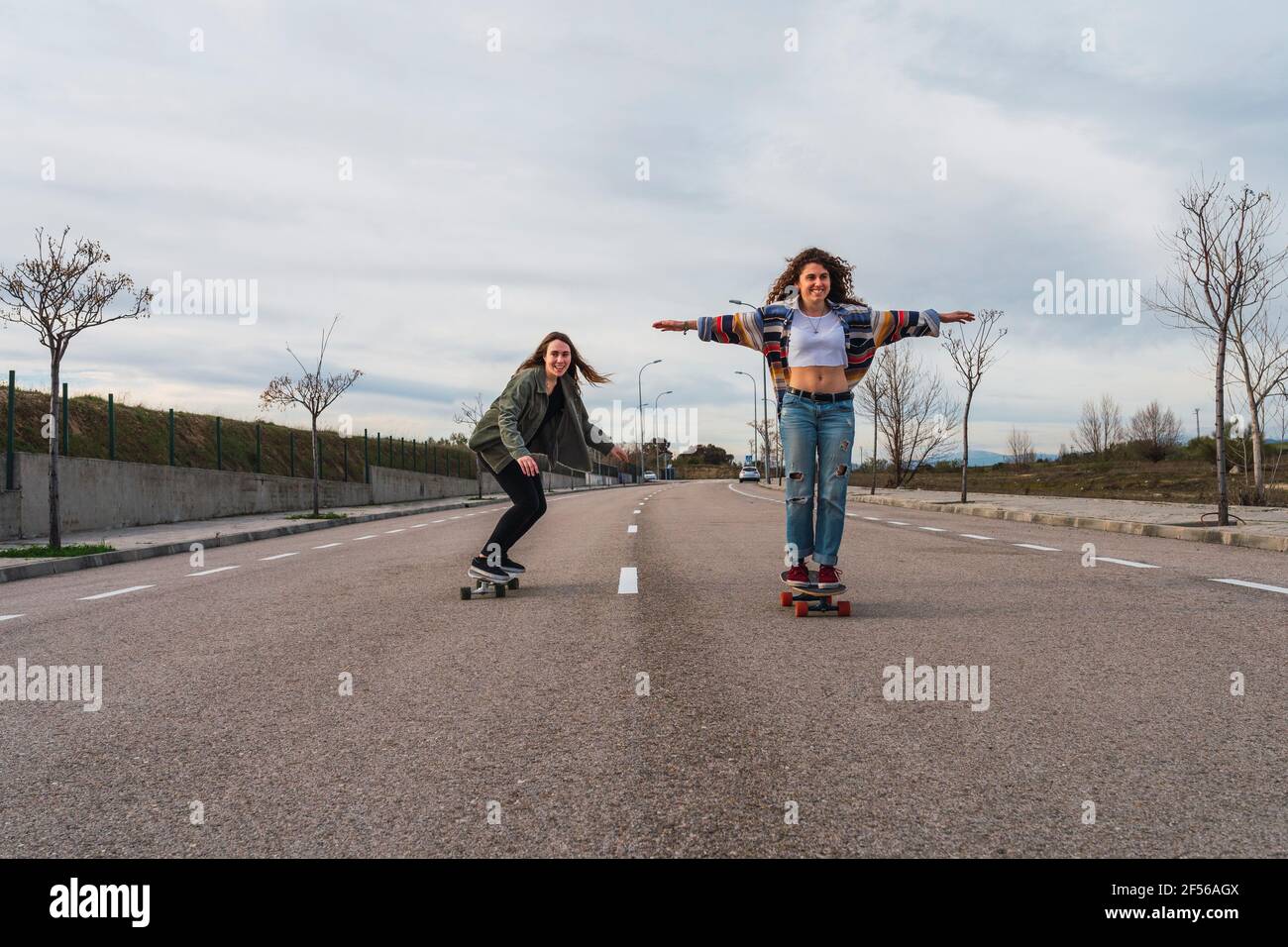 Mujeres amigas patinando en carretera contra el cielo Fotografía de stock -  Alamy