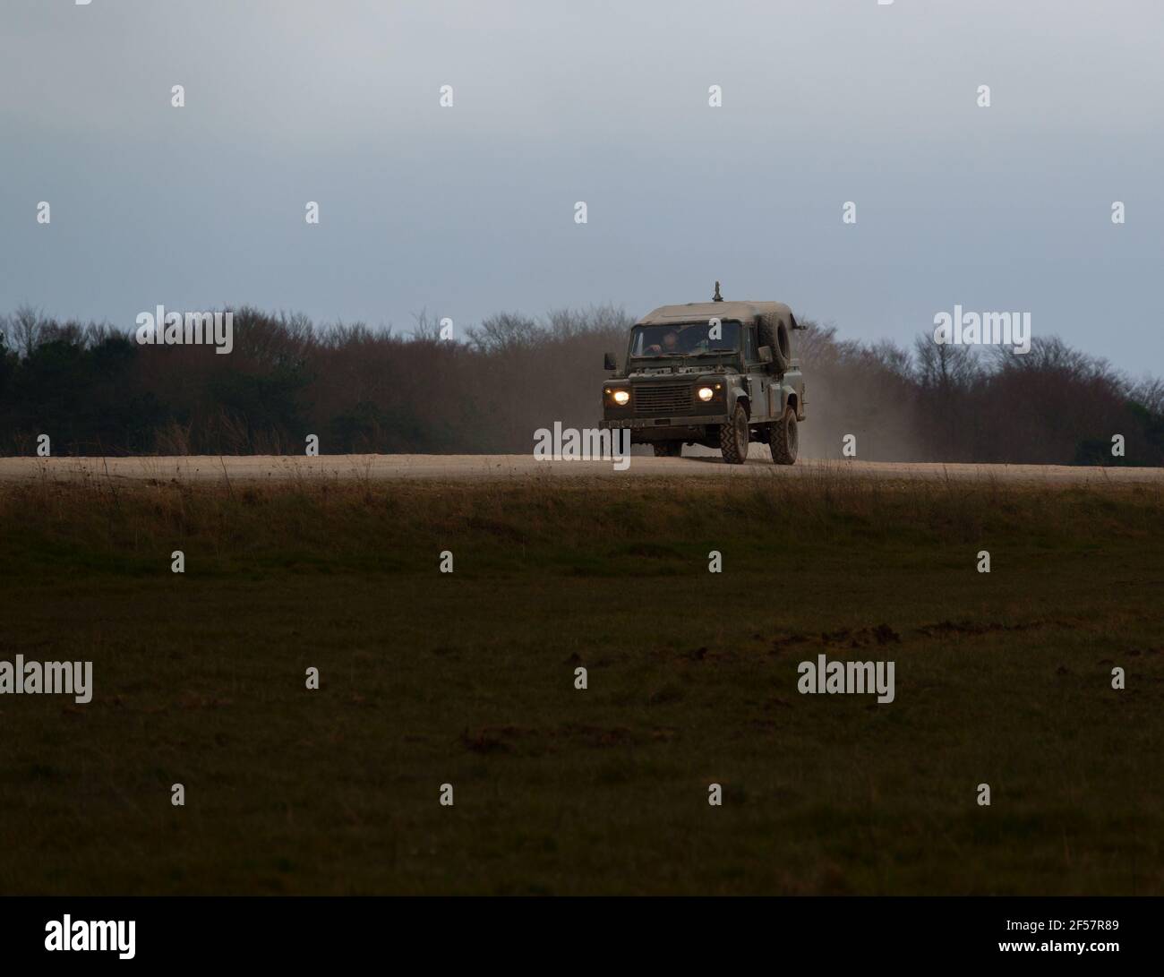 el defensor del land rover del ejército acelera a lo largo de una pista de piedra polvorienta en la llanura de salisbury wiltshire Foto de stock