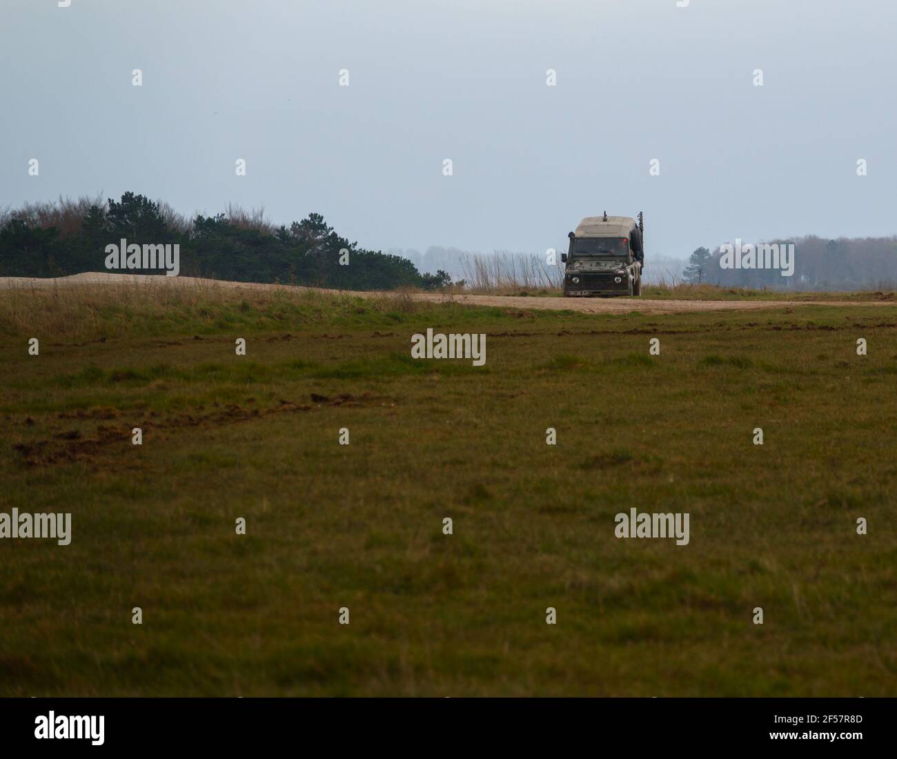el defensor del land rover del ejército acelera a lo largo de una pista de piedra polvorienta en la llanura de salisbury wiltshire Foto de stock
