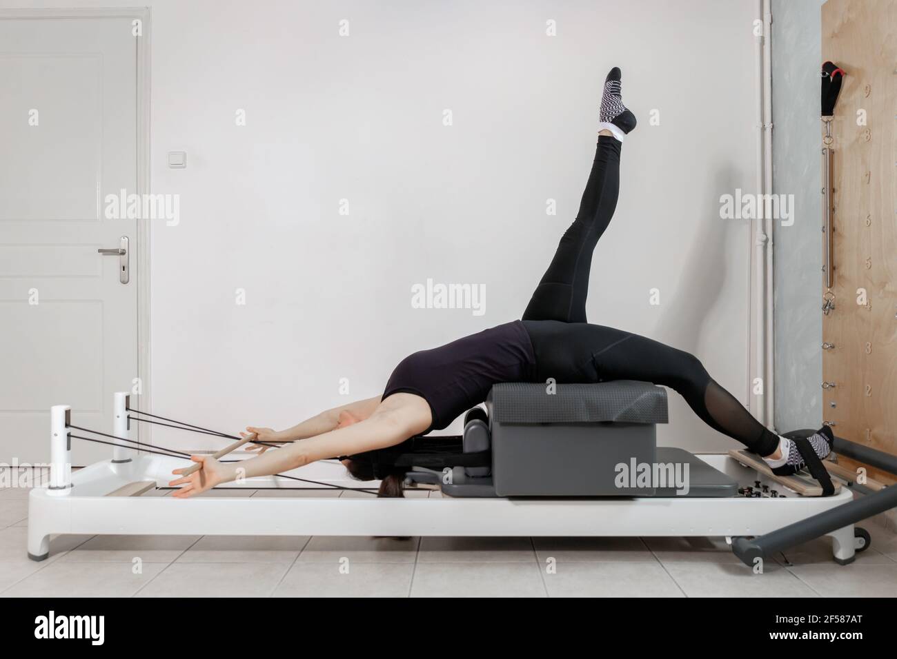 Una mujer haciendo ejercicios de pilates en una cama reformada