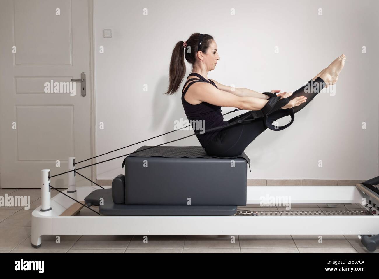 Una mujer haciendo ejercicios de pilates en una cama reformada Fotografía  de stock - Alamy