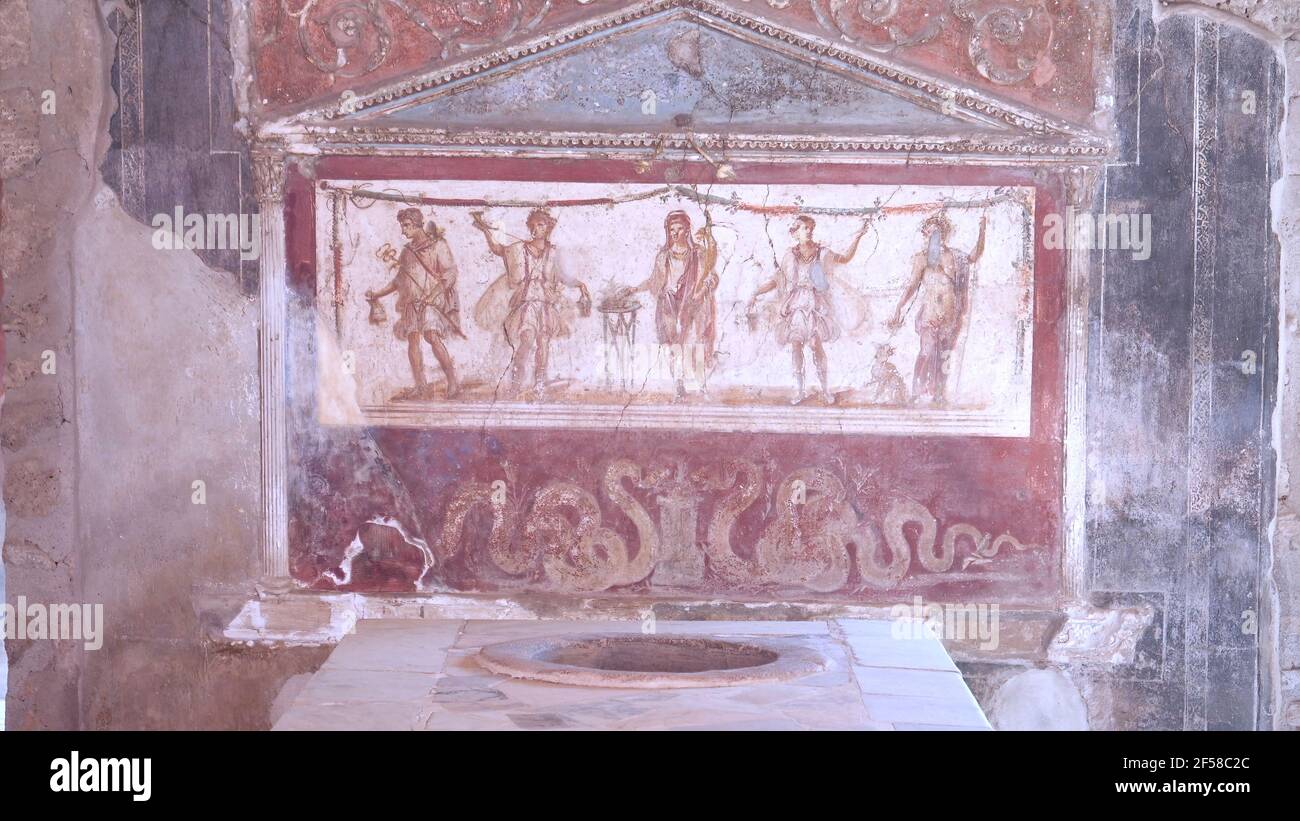 NÁPOLES, ITALIA- 13 DE JUNIO de 2019: Un larario pintado de cinco figuras en el termopolo de vetucio placidus en pompeya Foto de stock